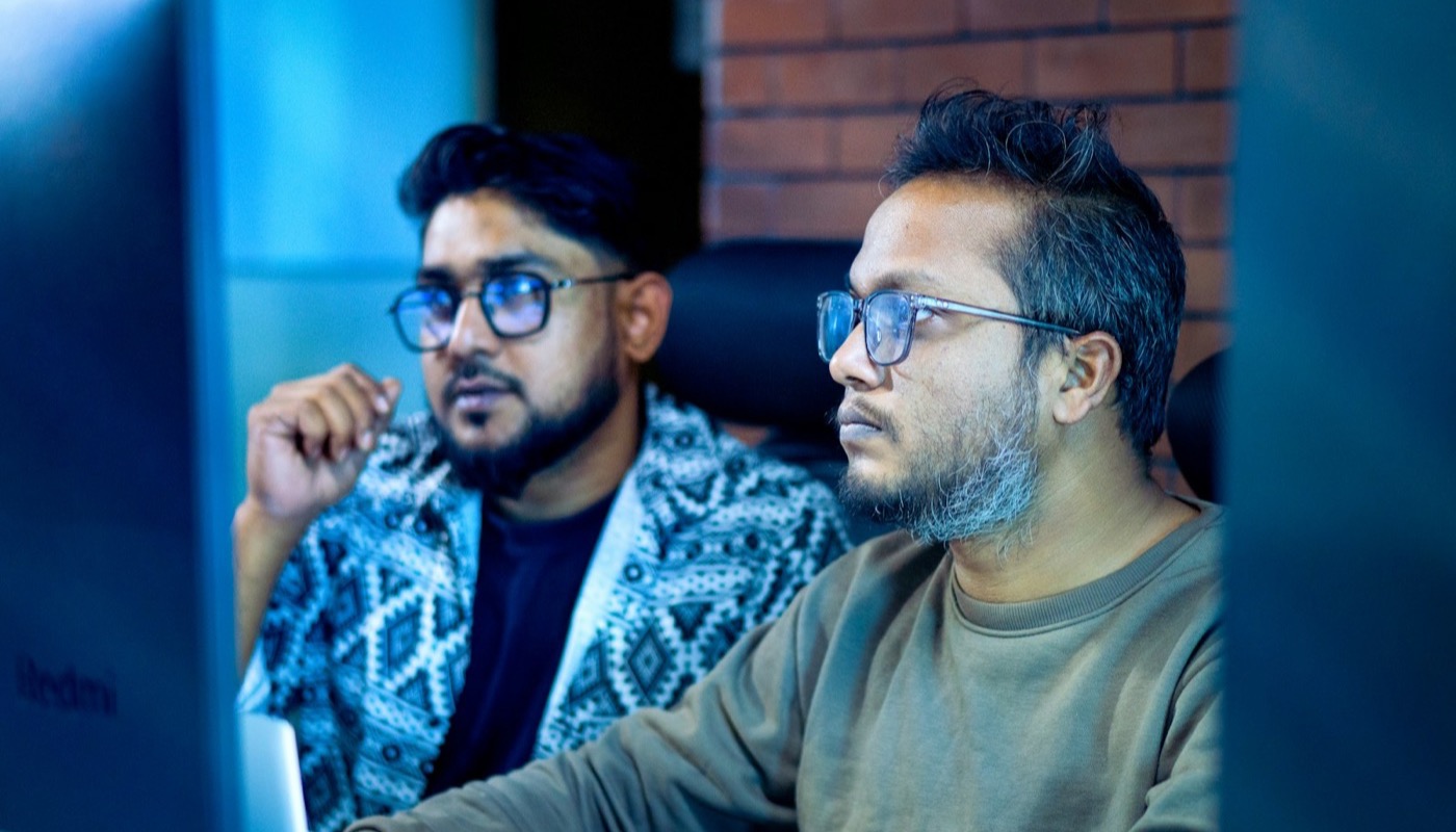 Two people studying content closely on a screen