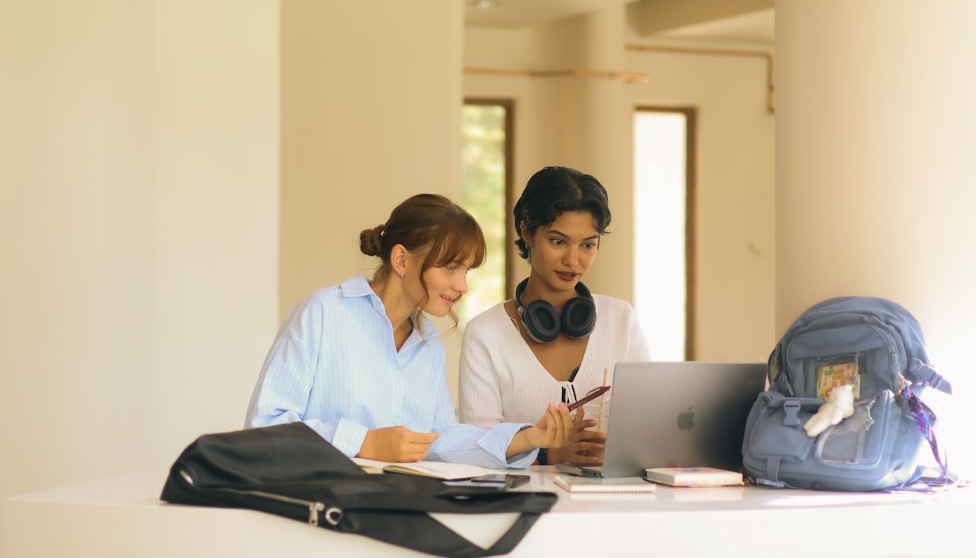 Two students looking at a laptop together at a study table
