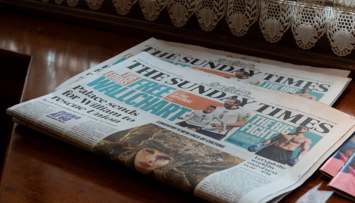 Copies of a newspaper on a wooden table