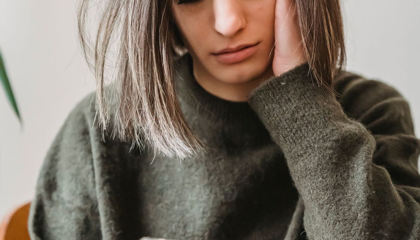 A person looking at a phone with a frustrated expression