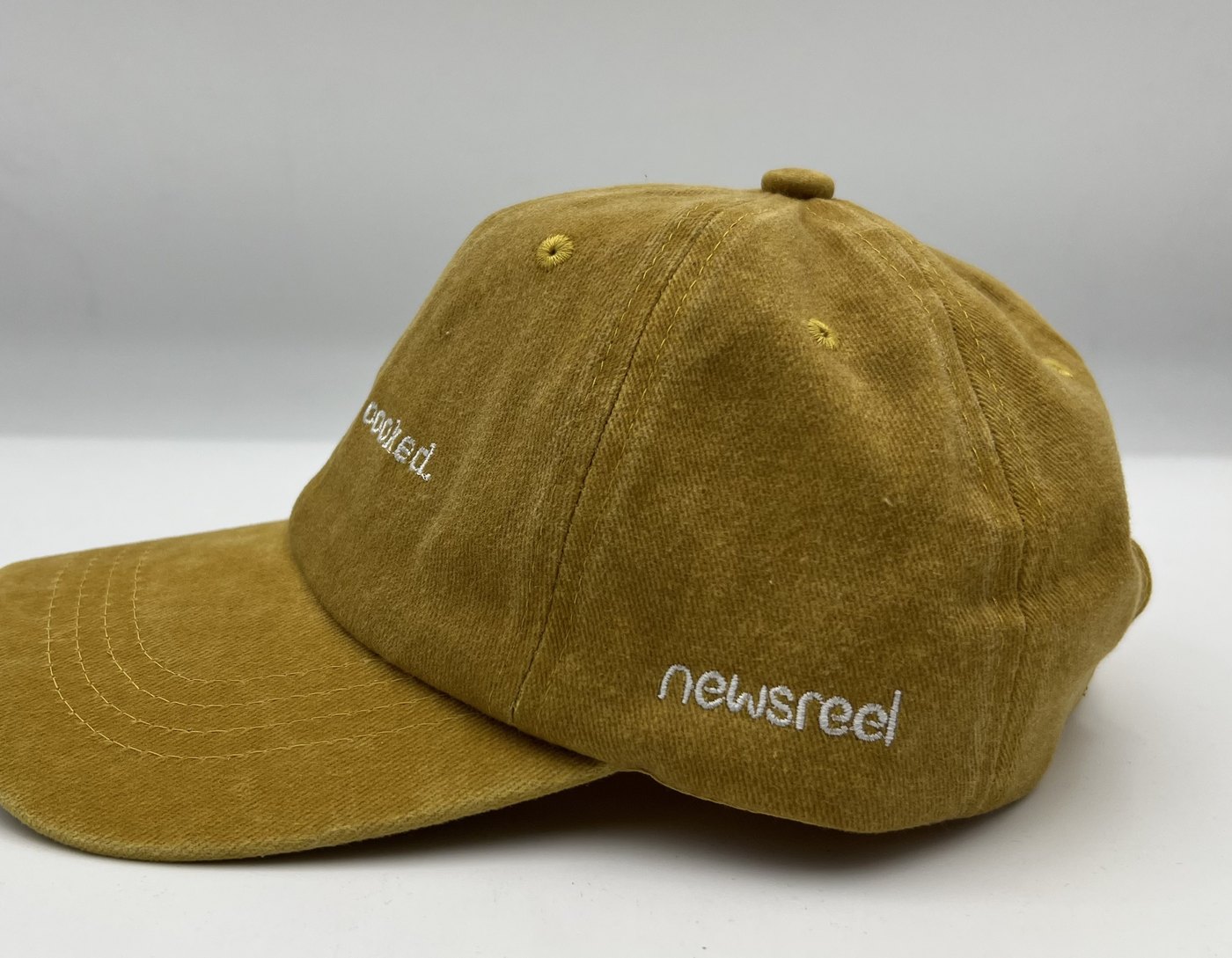 The Feed Is Cooked cap, side — embroidered 'newsreel'